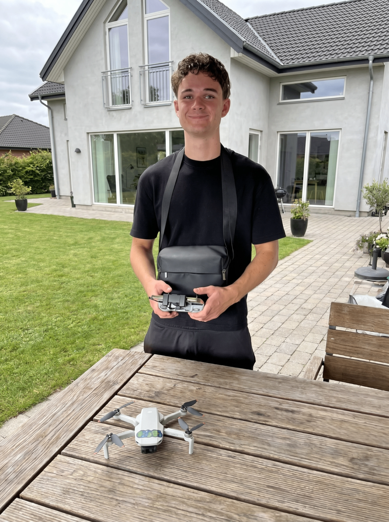 Wilhelm med drone klar til optagelse foran moderne dansk hjem